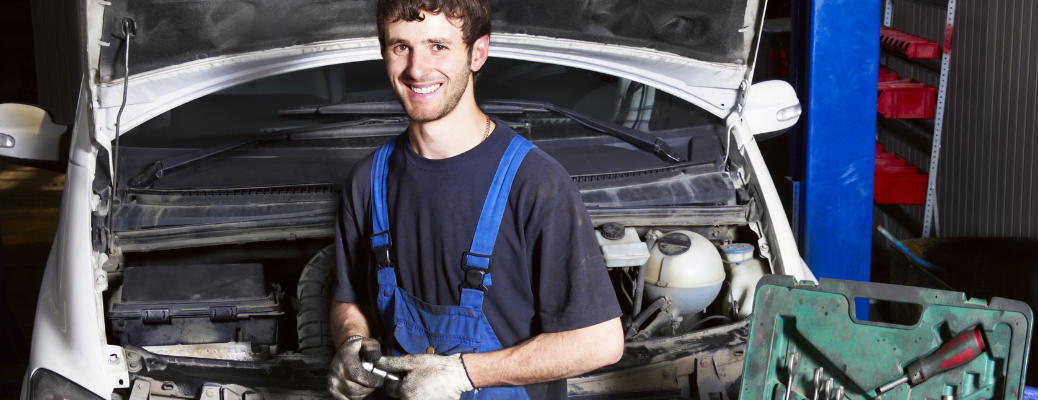 Mechanic posing in front of a vehicle