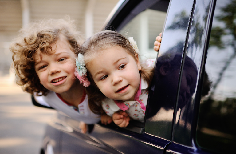 Kids looking from a car's window