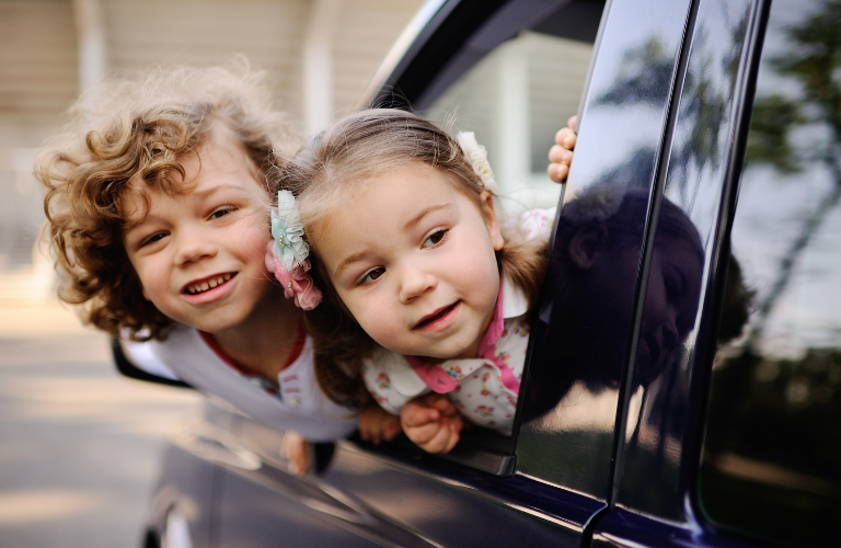 Kids looking from a car's window 