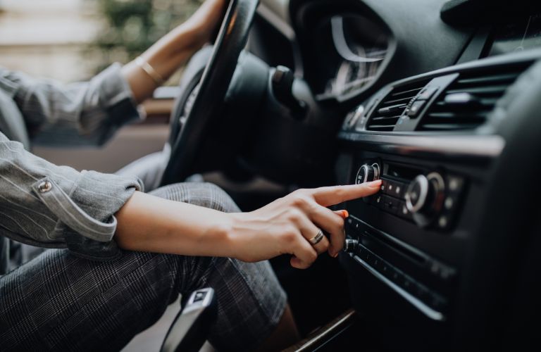 A woman pressing a button inside a car
