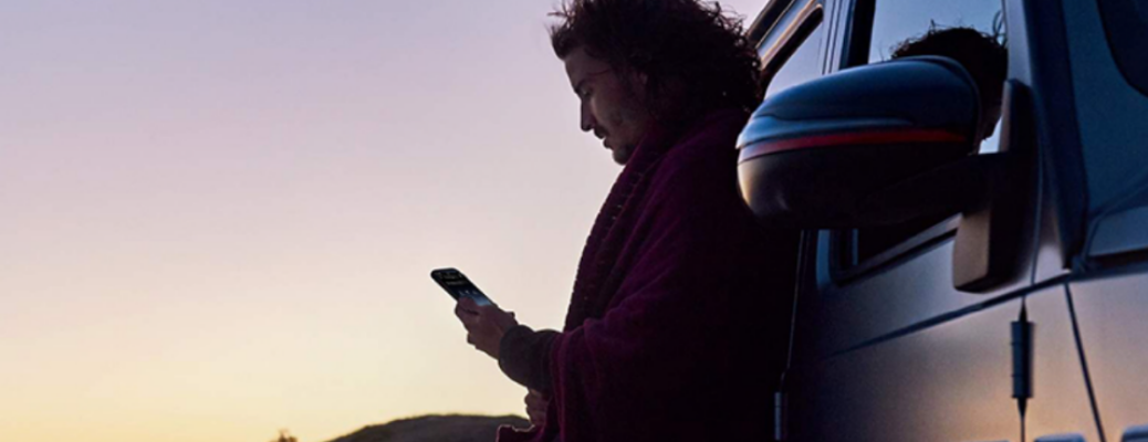 Man using a mobile near a vehicle