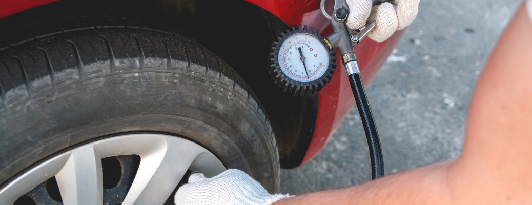 A person checking a vehicle's tire