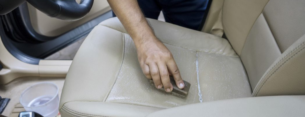 A person cleaning a vehicle's seats