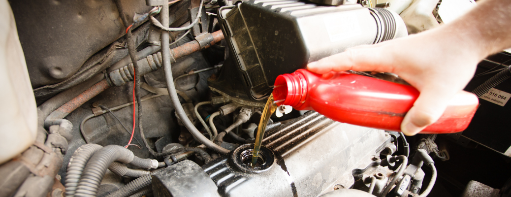 Mechanic pouring oil in a vehicle
