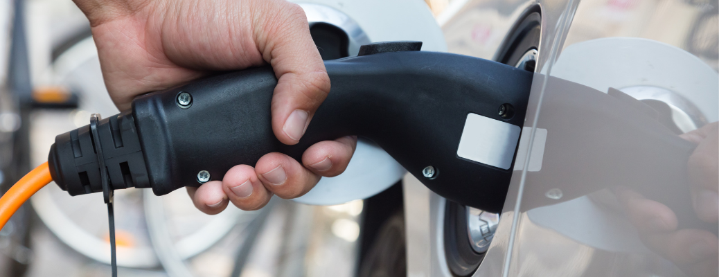 A man charging an electric vehicle