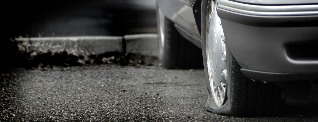 a car with a flat tire on pavement