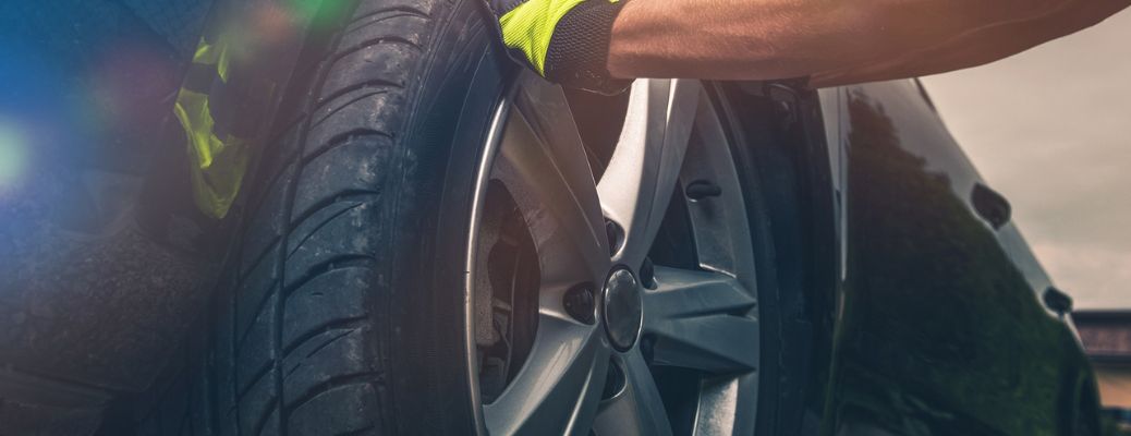 a technician checking the tire of a car
