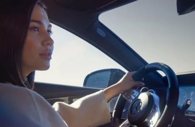 a woman in the front seat of a car driving