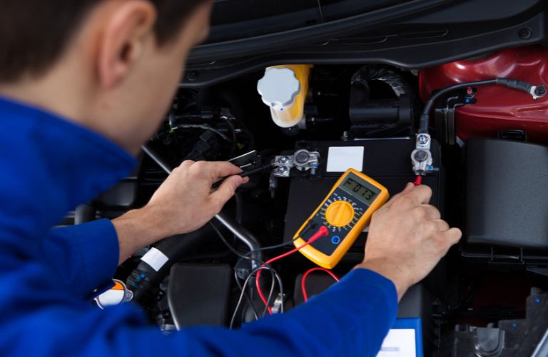 Technician checking a battery as part of the battery testing and inspection service
