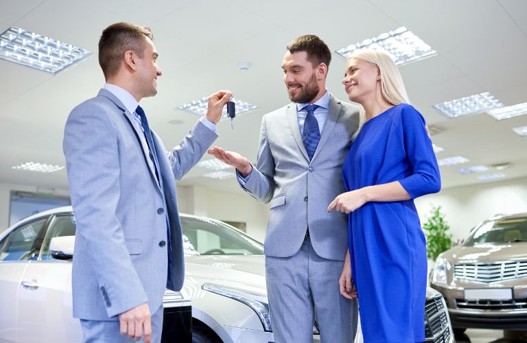 salesperson giving the keys to a couple