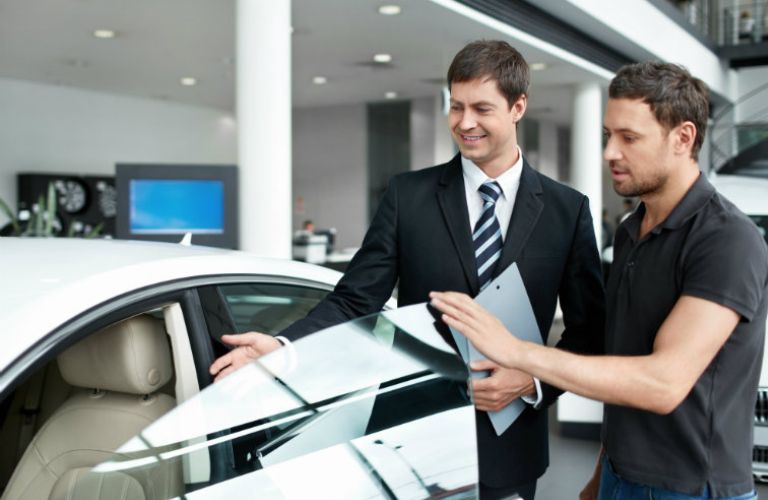 a salesperson and customer discussing a car's features