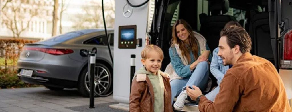 Mercedes-Benz charging at a public charging station with three people