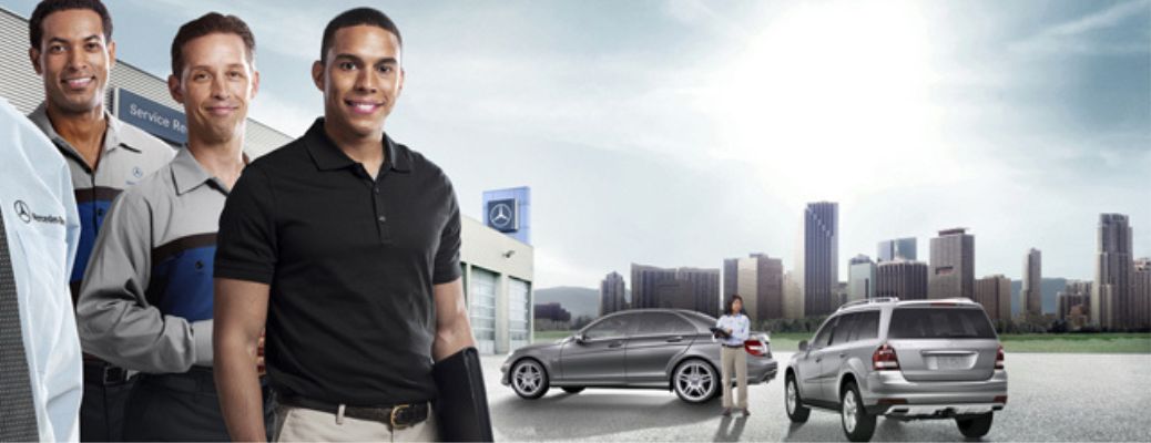 Three people smiling with two vehicle in the background