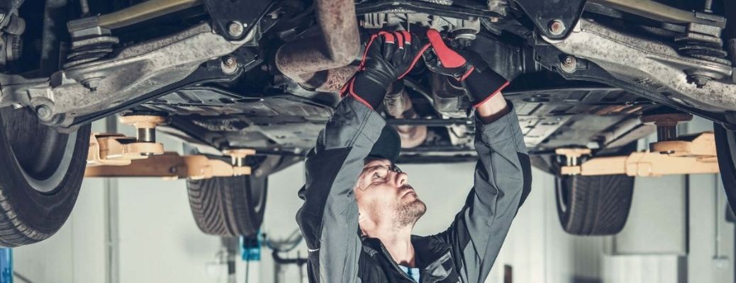 technician checking the underbody of a car