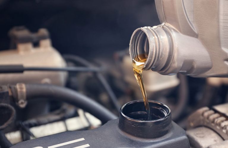 oil being poured from a can into the vehicle