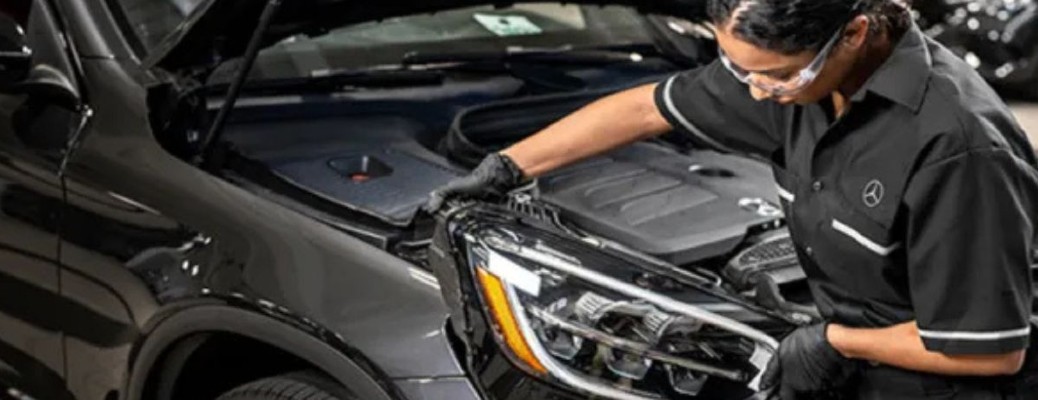 Mercedes-Benz technician looking under the hood of a car