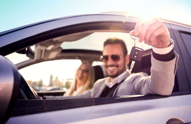A couple smiling inside a car