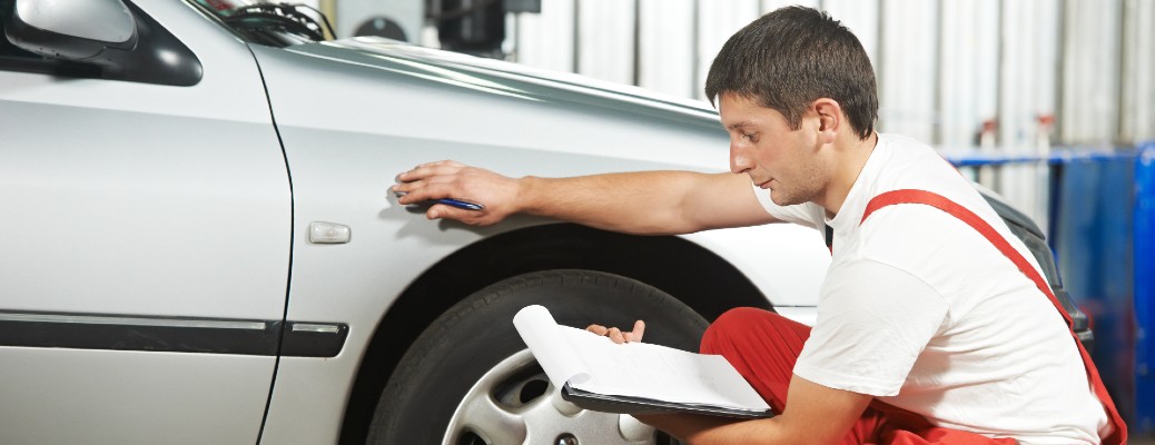 a man inspecting a car