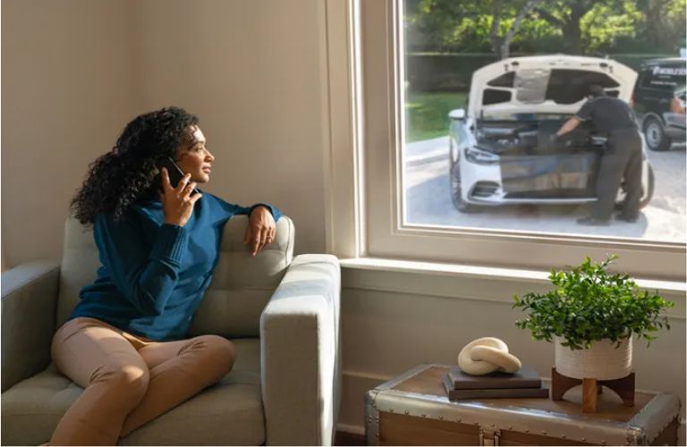 A woman talking over the phone and looking outside her window