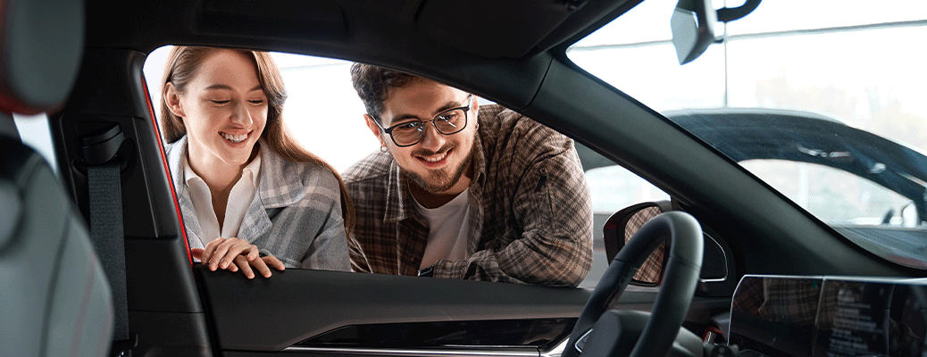 two people looking into the window of a car