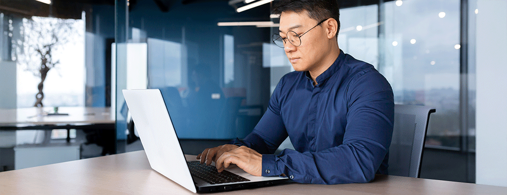 a person at a desk using a white laptop