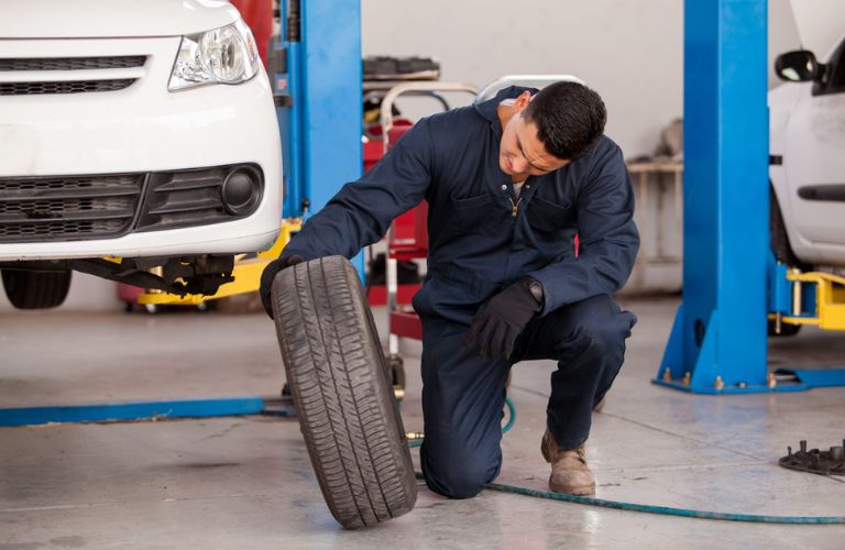technician inspecting a tire for damage