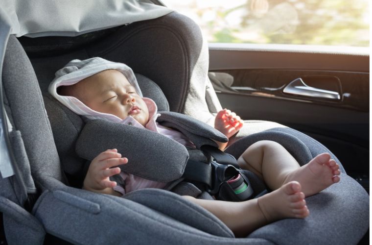 A baby sleeping inside a car.
