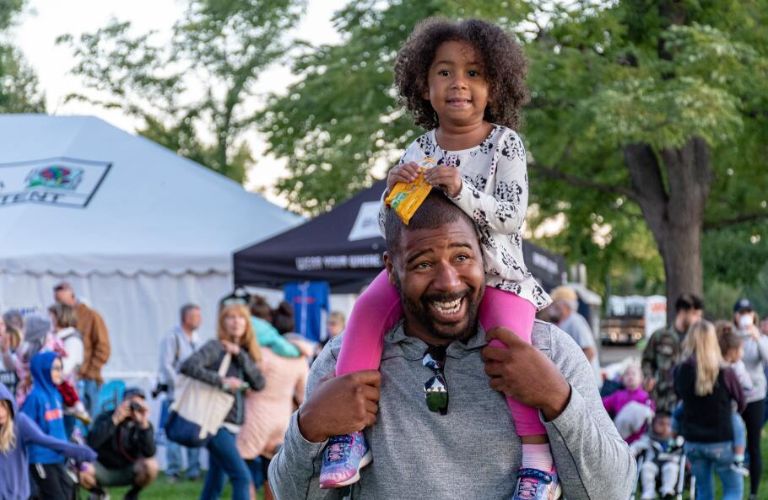 a young girl on her father's shoulders