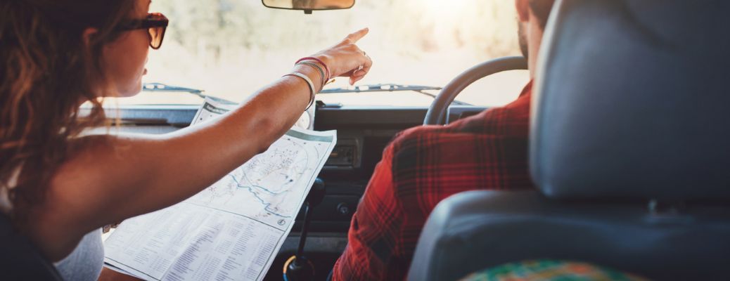 a couple reading a map in a car