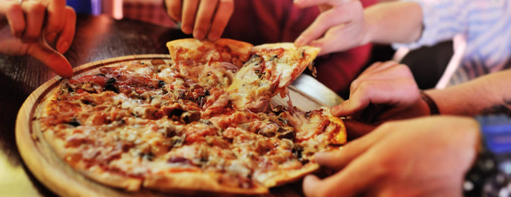 People sharing a pizza in one of the best pizza places in Scottsdale, AZ