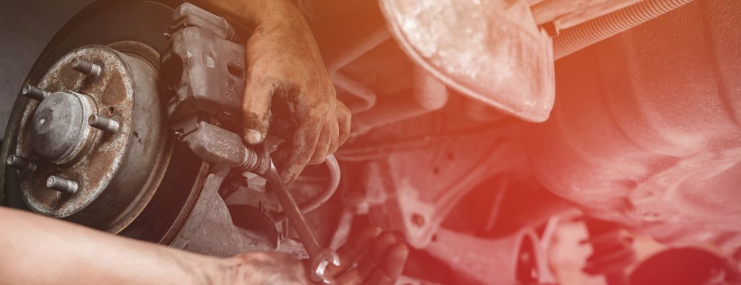 mechanic working on vehicle brake