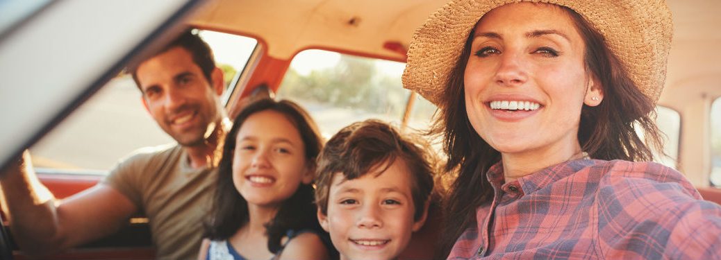 A family smiling inside a car