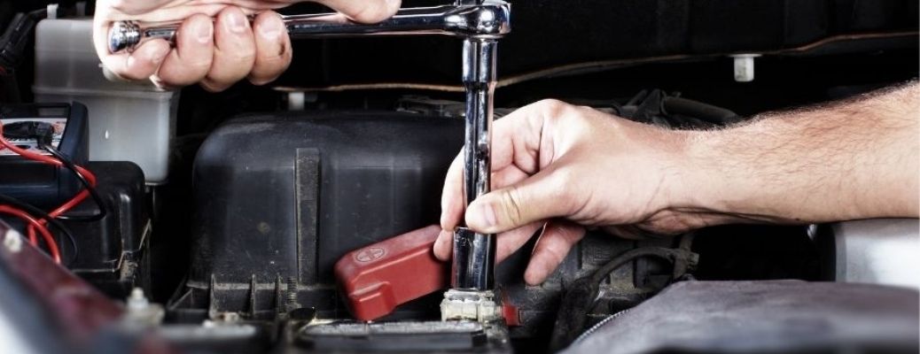 Hands of a mechanic working on a vehicle's engine