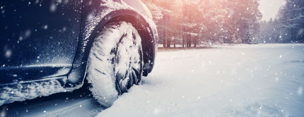 Closeup of a vehicle's tire covered in snow