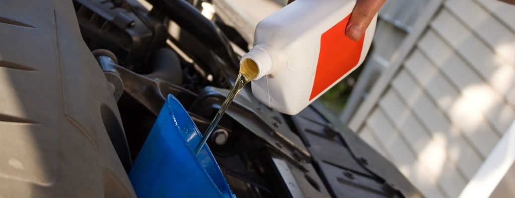 fresh oil being poured in a car