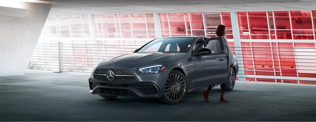 a woman getting out of the 2024 Mercedes-Benz C-Class Sedan