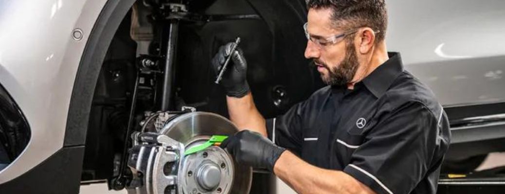 Certified Mercedes-Benz technician checking brake pads