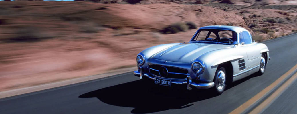 The gullwing Mercedes-Benz driving on a rural highway and into history.