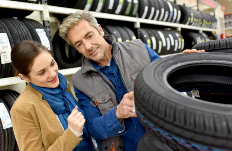 a couple choosing a tire from a tire shop