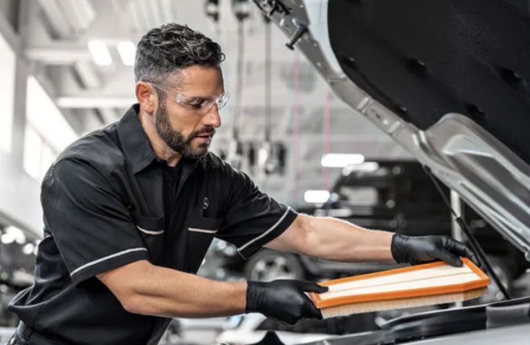 a Mercedes-Benz technician inspecting filter of a Mercedes-Benz