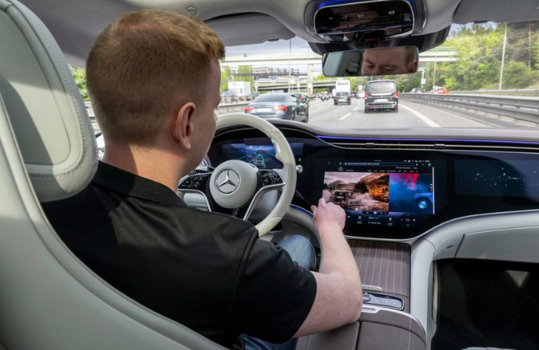 a man in a Mercedes-Benz using the Mercedes-Benz DRIVE PILOT Automated Driving Technology