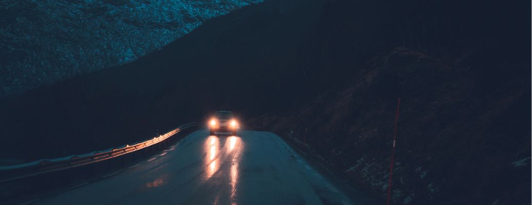 image of a car with headlights on during nighttime