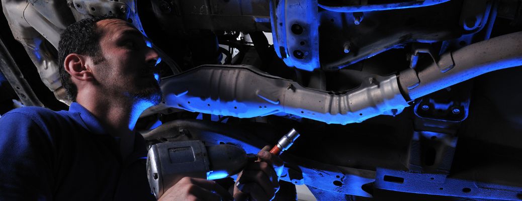 a technician working under the hood of a car