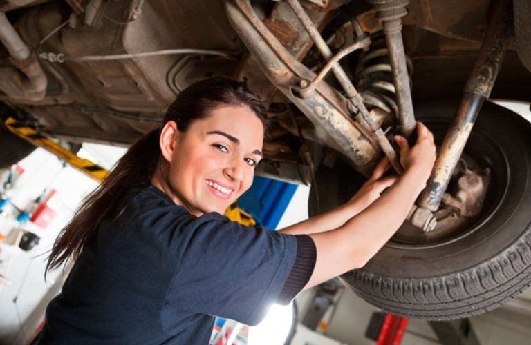 a woman working under the hood of a car