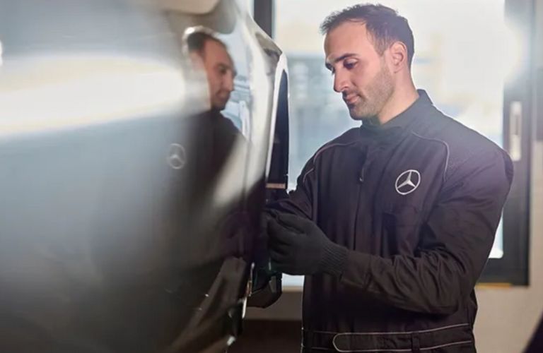 a Mercedes-Benz technician inspecting the tire