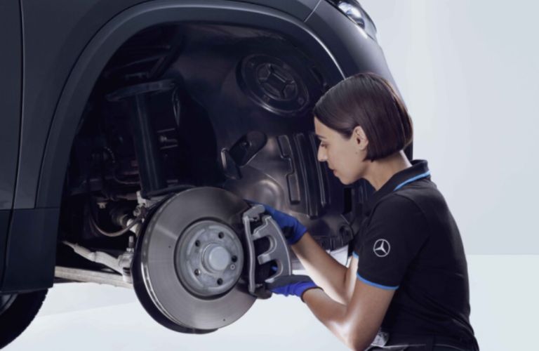 a technician checking the wheel of a Mercedes-Benz