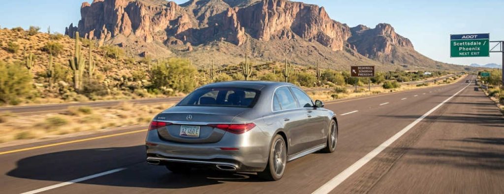 A Mercedes sedan driving on a hot desert highway near Scottsdale