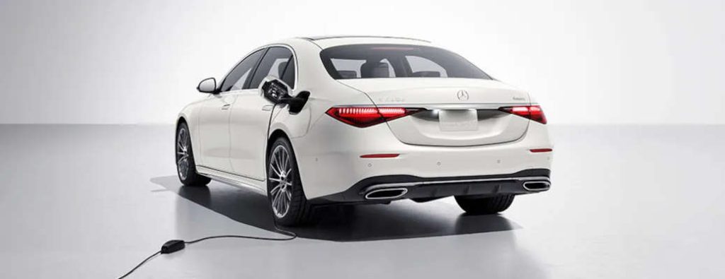 A Mercedes-Benz plug-in hybrid sedan at a home charging station