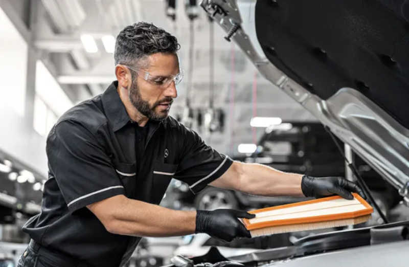 A Mercedes-Benz service technician performing essential winterizing maintenance in the Arizona desert