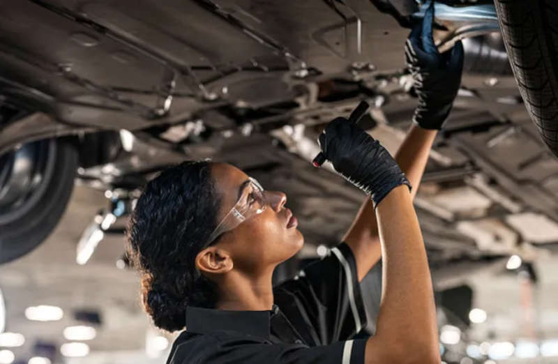 A Mercedes-Benz service technician inspecting the brakes of a Mercedes vehicle